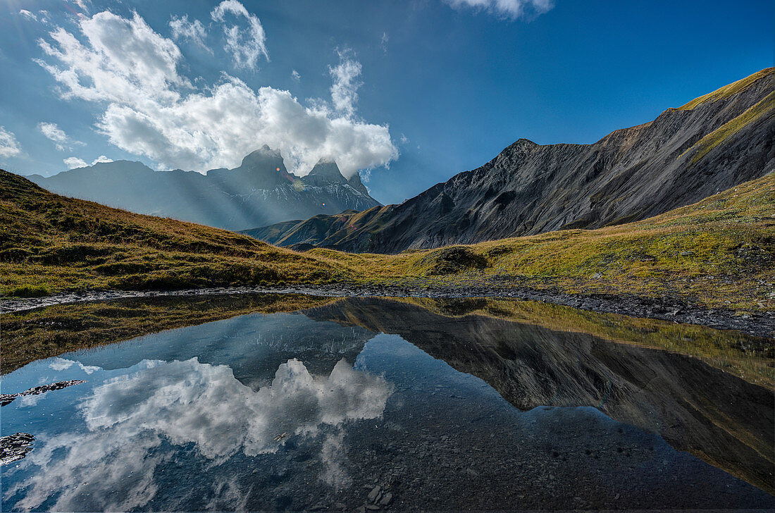 Die Aiguille d'Arves bei Sonnenaufgang spiegelt sich in einem kleinen Alpensee, Ecrins, Savoie, Frankreich