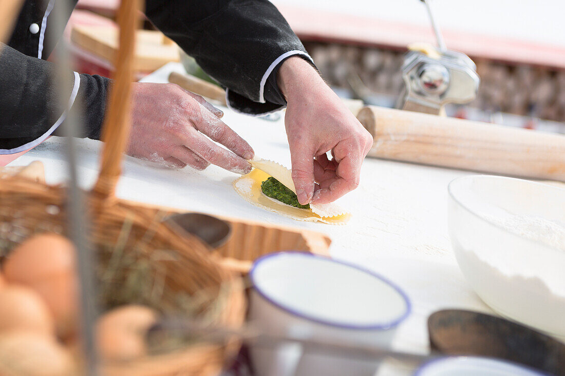 Eine Nahaufnahme von einem Koch, der die Schlachtung vorbereitet, schlutzkrapfen, gefüllt von Spinat, Provinz Bozen, Südtirol, Trentino Alto Adige, Italien, Europa