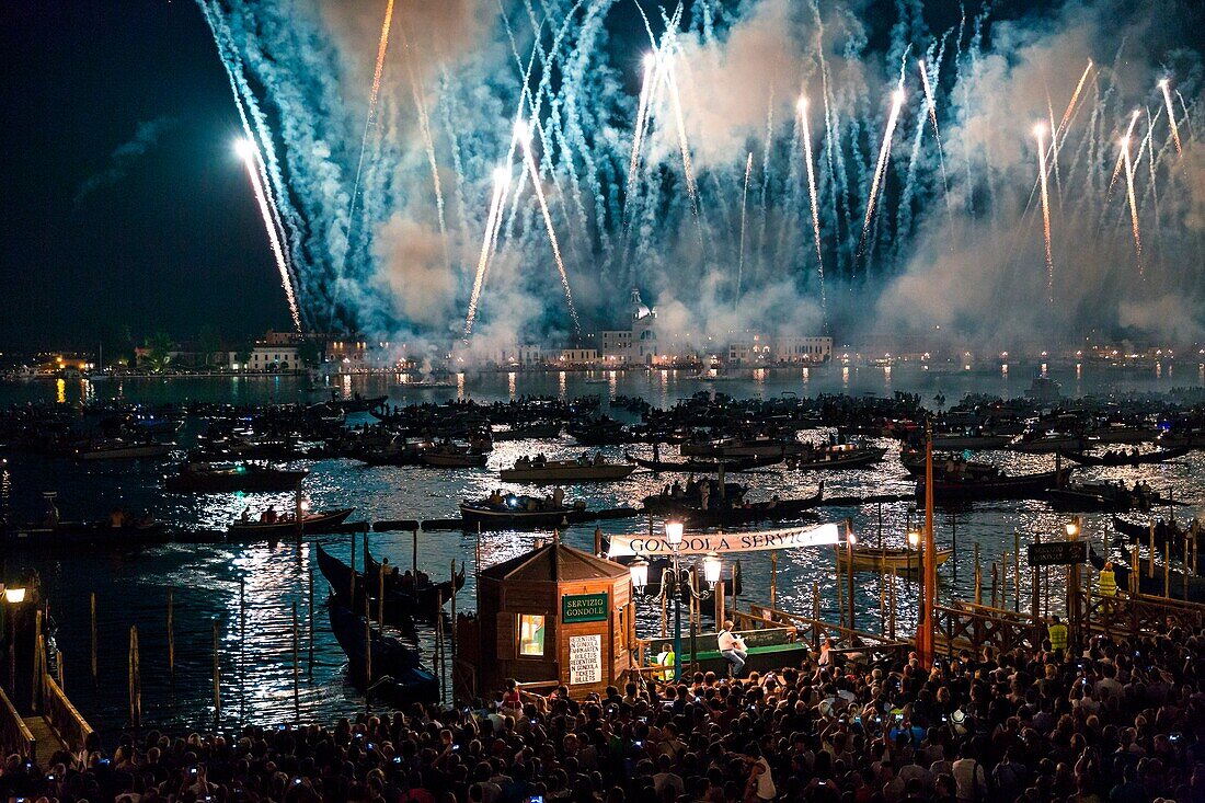 Die Menschen bewundern das Feuerwerk und die Gondeln auf der Lagune während der Festa del Redentore in Venedig Venetien Italien Europa