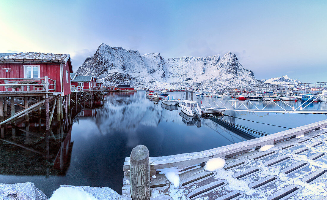Typische rote Häuser spiegelt sich im Meer in der Dämmerung, Reine, Lofoten Inseln Norwegen Europa
