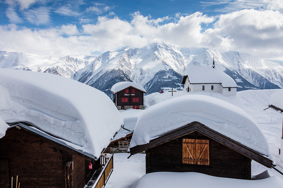 Schneebedeckte Berghütten und Kirche umgeben von hohen Gipfeln Bettmeralp Bezirk von Raron Kanton Wallis Schweiz Europa