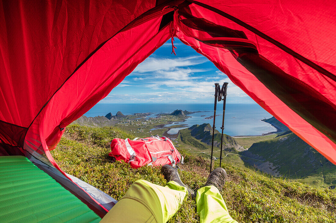Zelt und Wanderer auf Bergspitze mit Blick auf das Meer Sorland Vaeroy Insel Nordland Grafschaft Lofoten Archipel Norwegen Europa