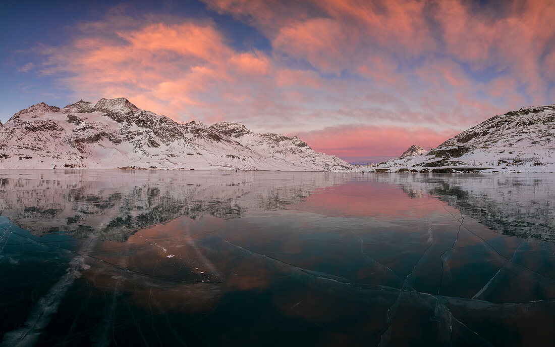 Panorama des gefrorenen Lago Bianco unter rosa Wolken am Morgen Bernina Pass Kanton Graubünden Engadin Schweiz Europa