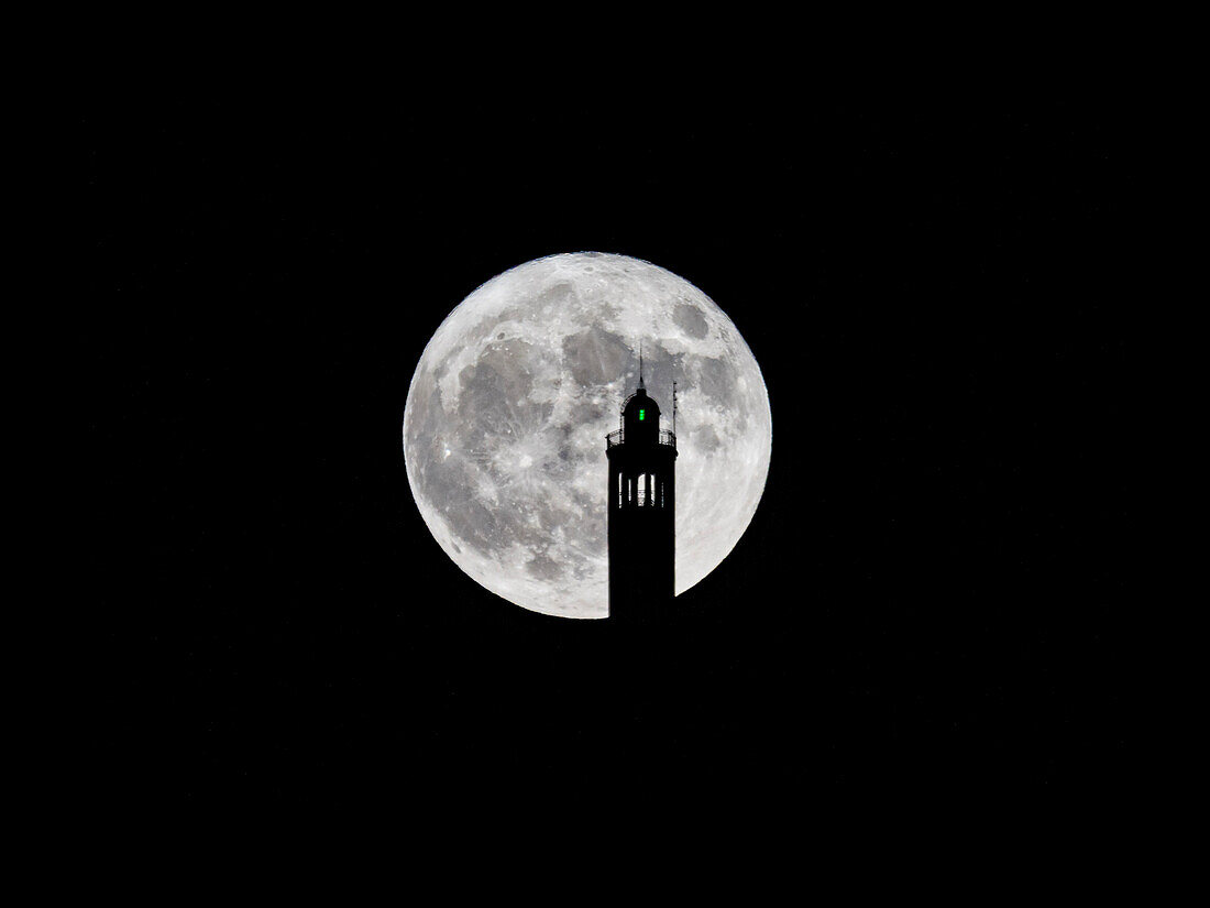 Big full moon behind the lighthouse of Brunate, above Como, province of Como, Lombardy, Italy