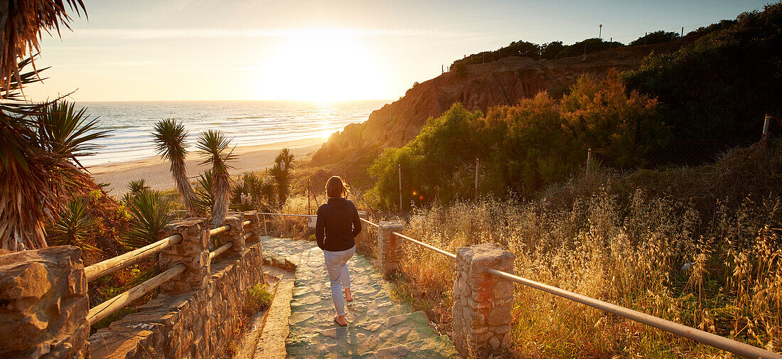 Frau geht Treppe zum Strand hinunter , Andalusien, Südwestküste Spanien, Atlantik, Europa