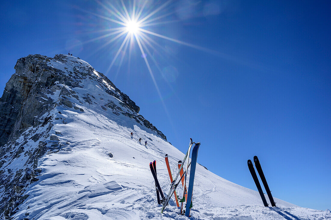 Skis at depot, persons in background ascending towards Reichenspitze, Reichenspitze, Zillertal Alps, Tyrol, Austria