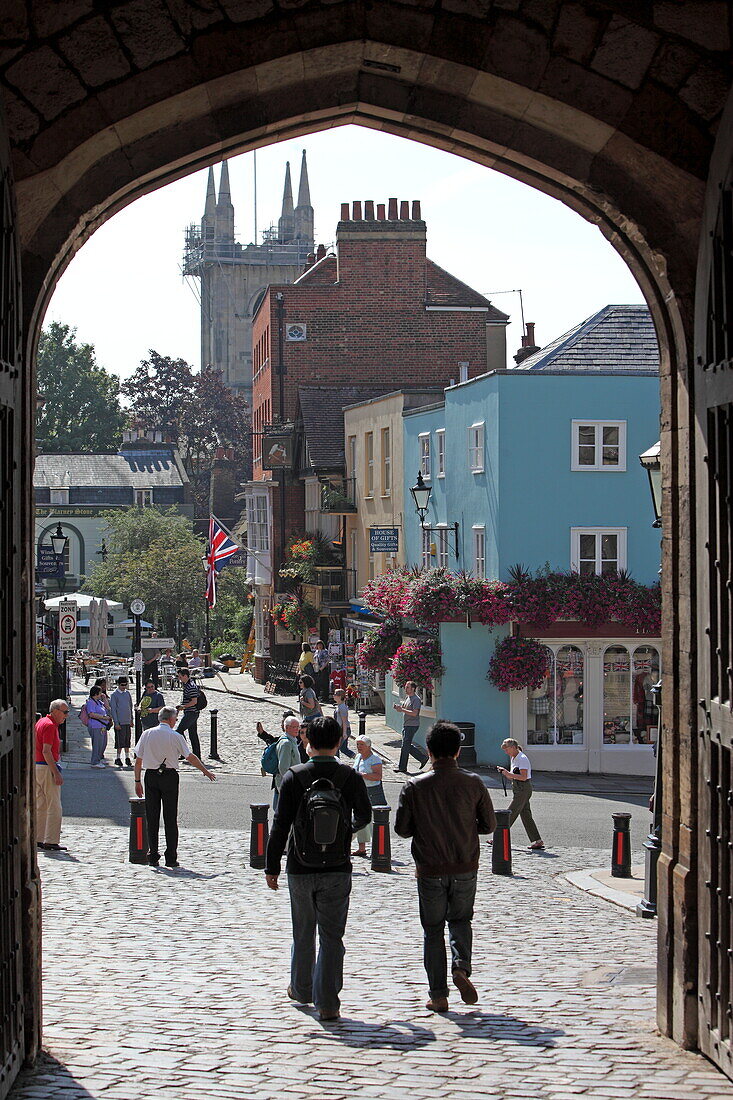 View through the entrance gate of WIndsor Castle and colorful houses of St. Alban's Street, Windsor, Berkshire, England