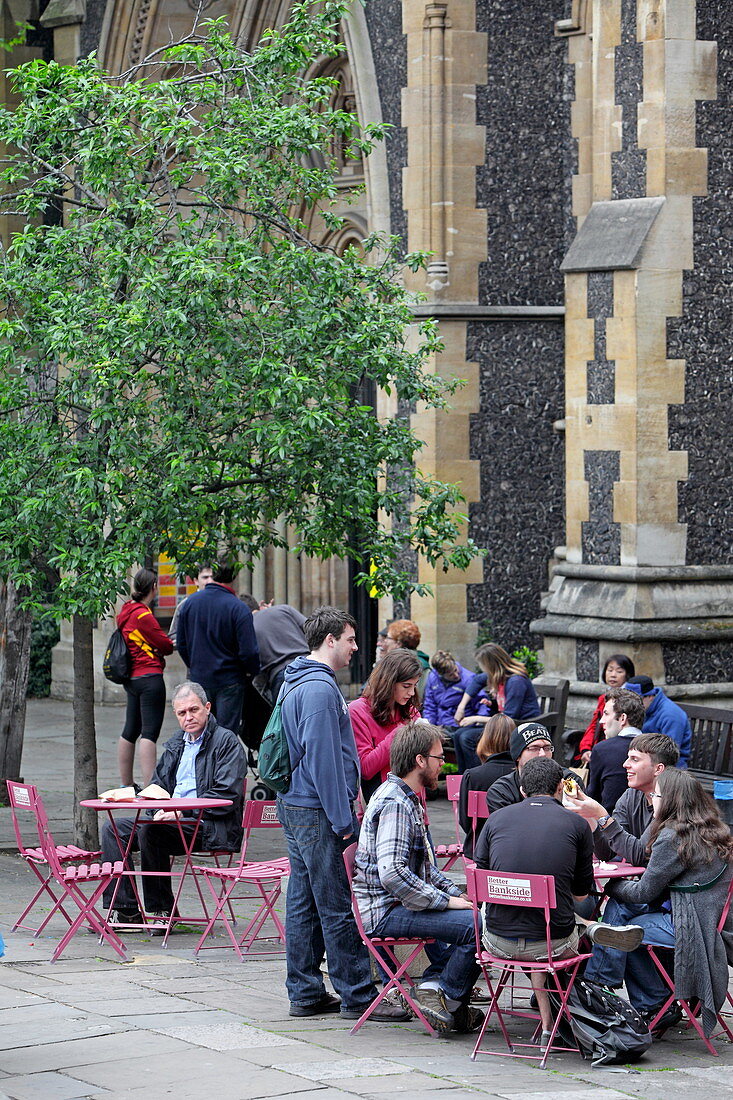 Visitors of Borough Market enjoy their purchases, Southwark Cathedral, London, England