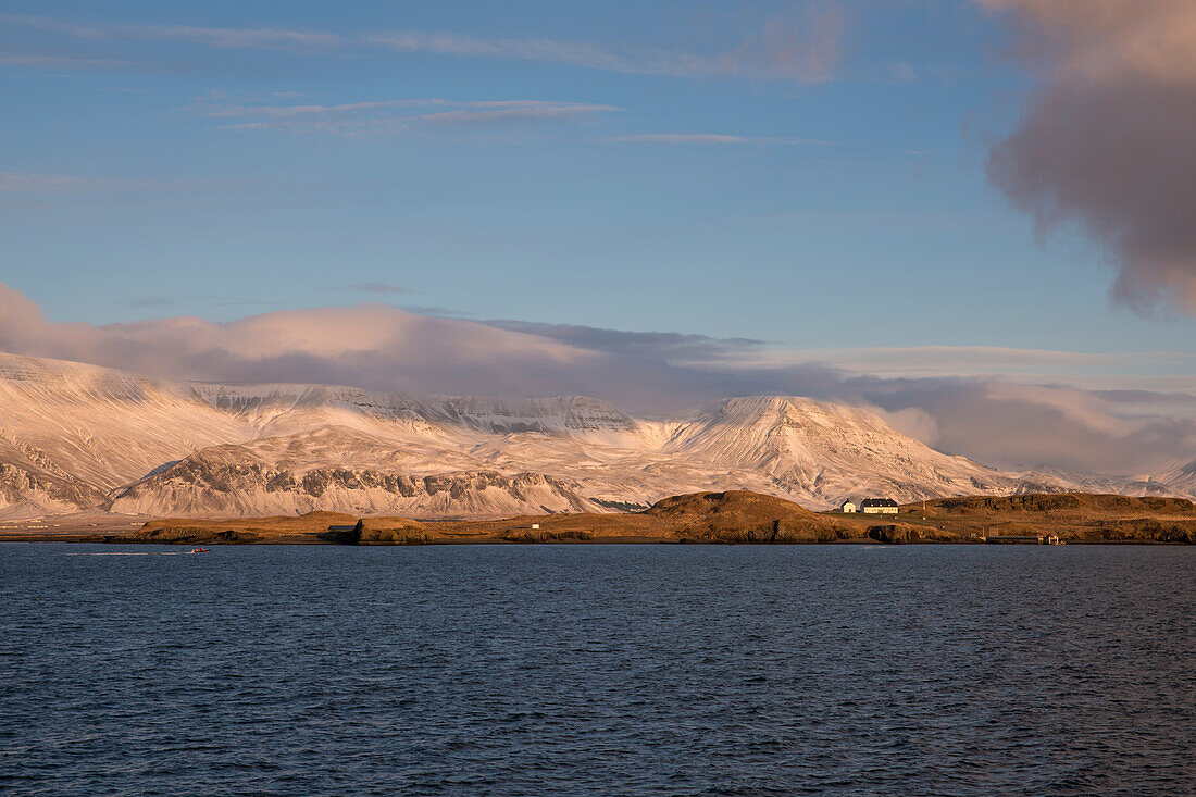 Verschneite Landschaft an der Küste nahe Reykjavík mit Blick auf das Gebirge Esja in Wolken, Reykjavik, Island, Iceland, Europa