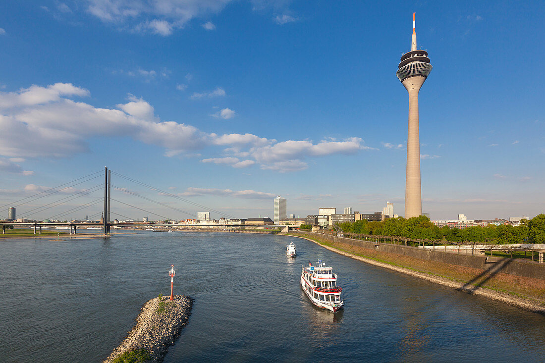 Excursion ships entering Medienhafen, view over the Rhine river to Rheinknie bridge and television tower, Medienhafen, Duesseldorf, North Rhine-Westphalia, Germany