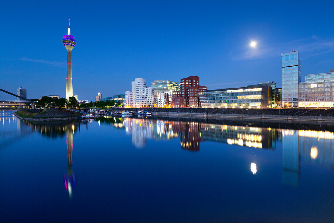 Full moon, television tower and Neuer Zollhof (Architect: F.O. Gehry), Medienhafen, Duesseldorf, North Rhine-Westphalia, Germany