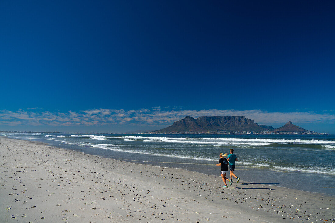 Joggers running on Blouberg Beach in the early morning, with Table Mountain in the background, Cape Town, South Africa, Africa