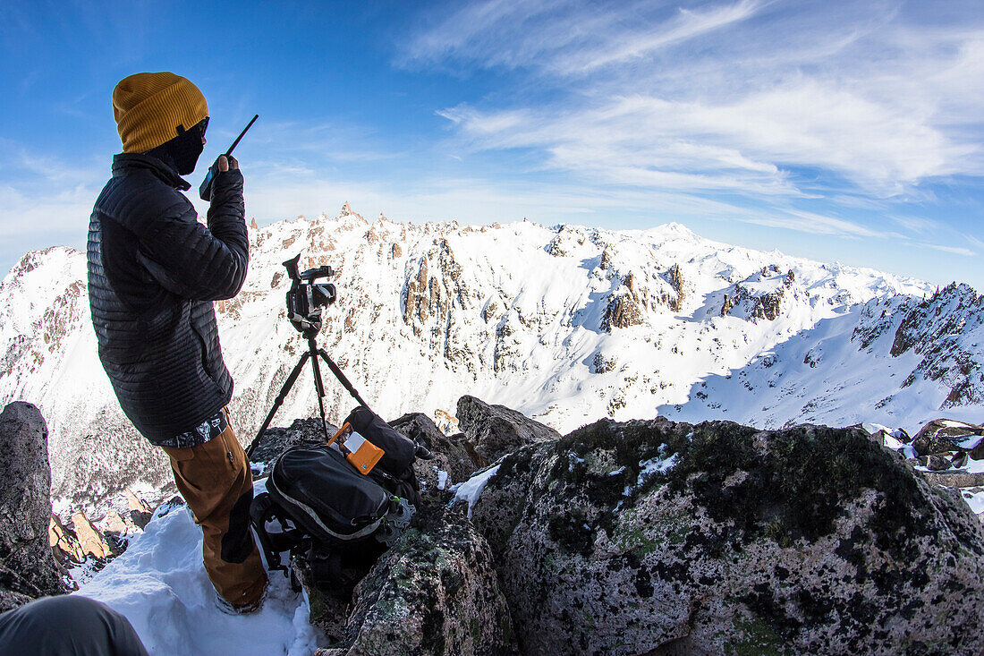 Ein Snowboard-Filmer, der mit den Reitern im Backcountry um Cerro Catedral in Argentinien kommuniziert