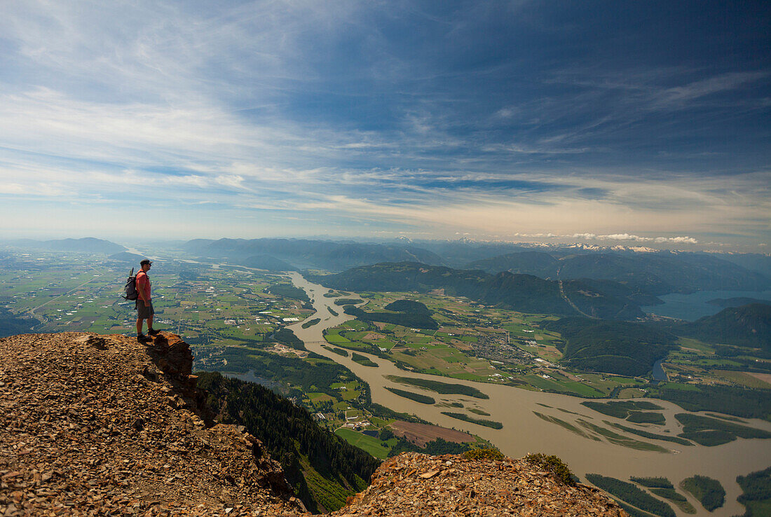 Hiker looking down at view of Fraser Valley from top of Cheam Mountain
