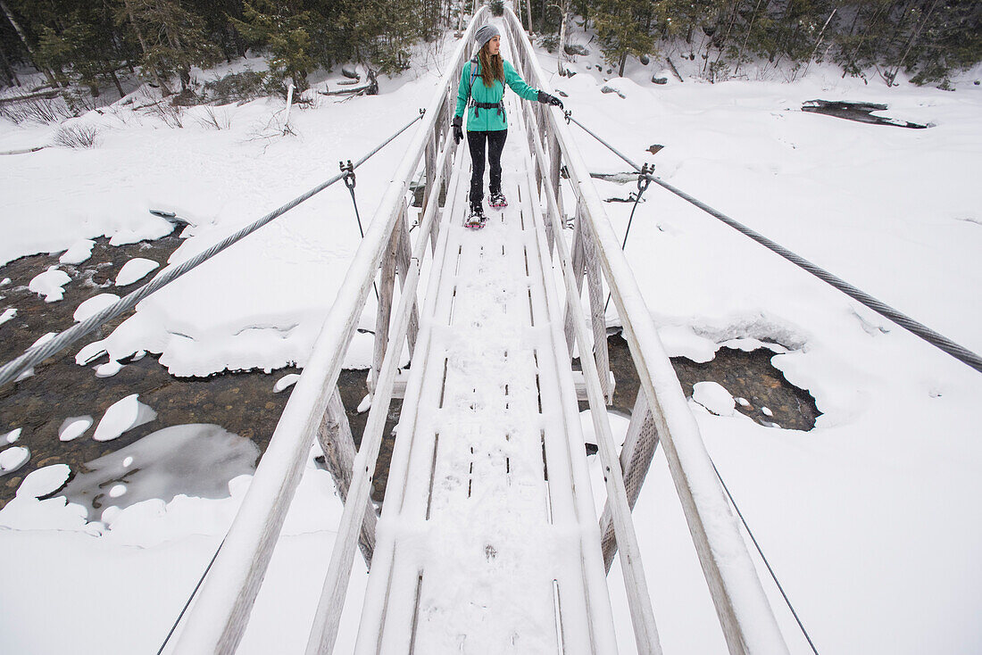 Frau wandert über die Fußgängerbrücke im Winter