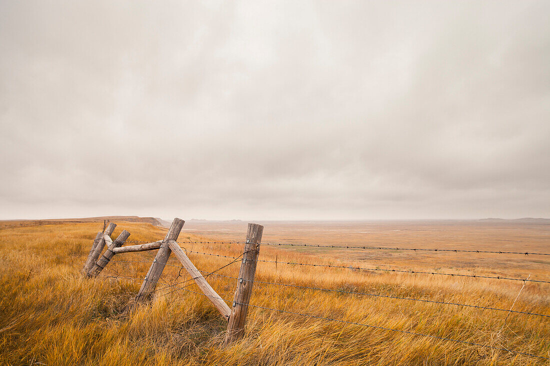 A section of a fence overlooks the plains of South Dakota, United States.