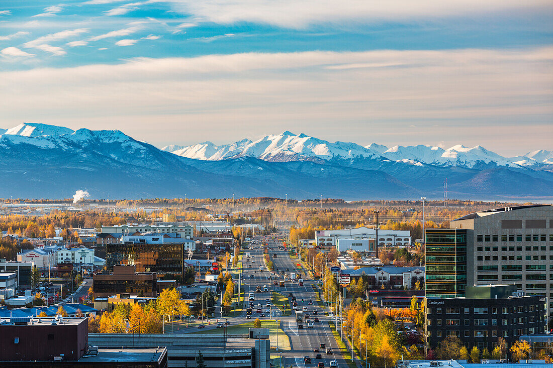 Aerial view of C Street in Anchorage with snow capped Kenai Mountains in the background in autumn, Southcentral Alaska, USA