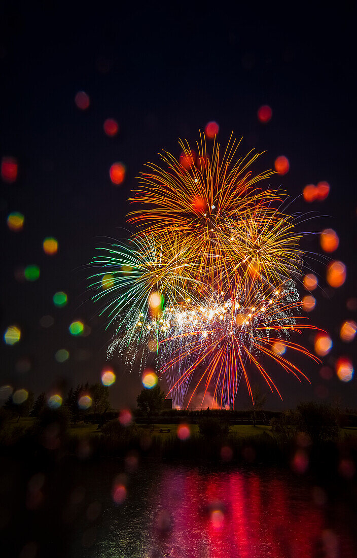 'Bunte Feuerwerk-Display spiegelt sich in Wasser am Tag der Kanada; Edmonton, Alberta, Kanada'