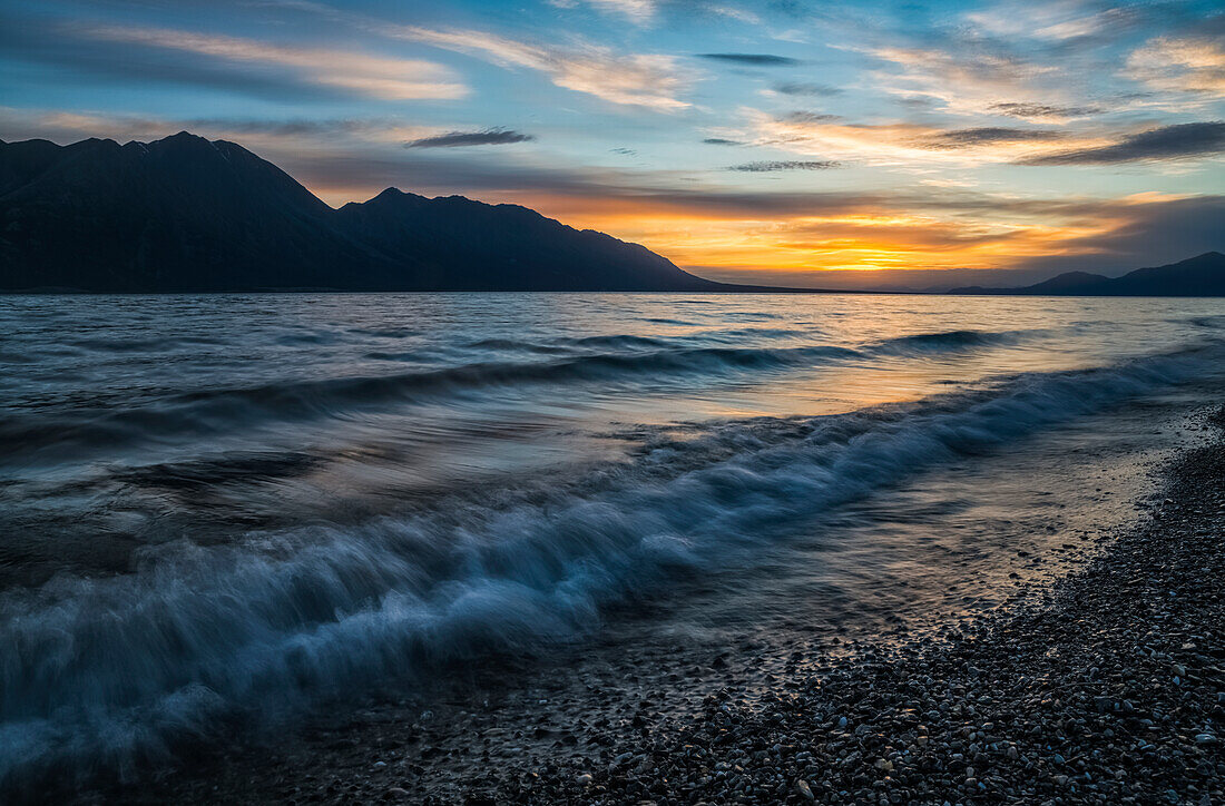 'Surf along the shore of Kluane Lake at sunset; Yukon, Canada'