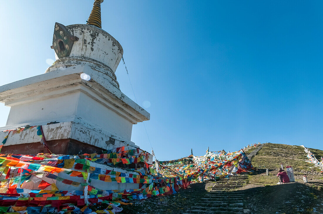 'Buddhistische Stupa und tibetische Flaggen auf der Straße in der Nähe von Litang Dorf, erste tibetische Stadt aus Chengdu; Litang, Sichuan, China'