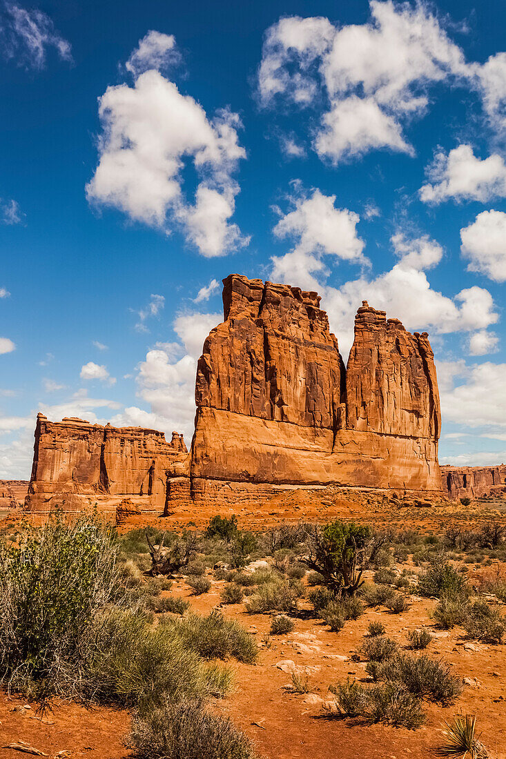 'A rugged rock formation in the desert under blue sky with cloud; Arizona, United States of America'