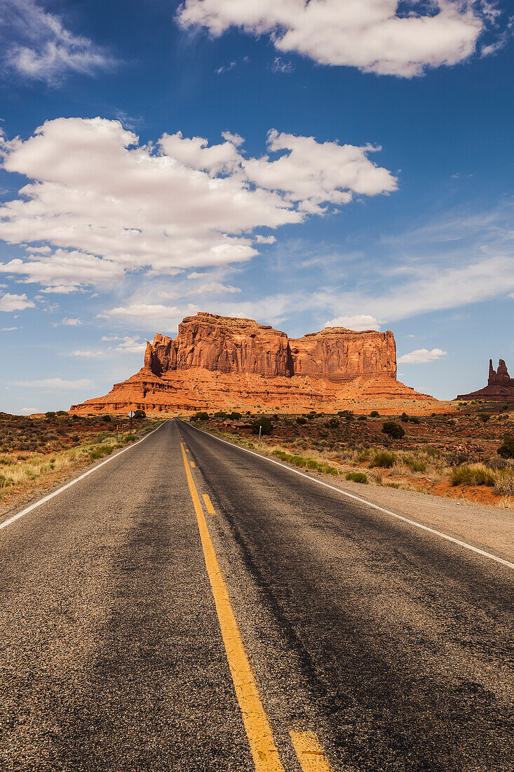 'Eine Straße, die zu einer schroffen Felsenformation in der Wüste führt; Arizona, Vereinigte Staaten von Amerika'