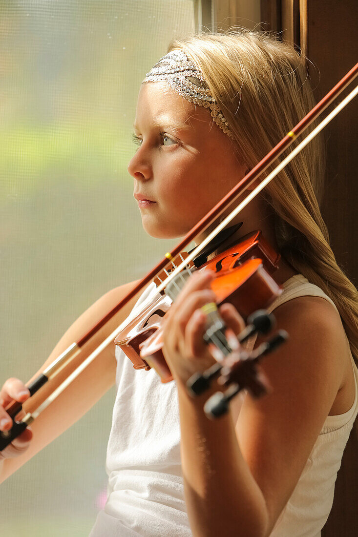 'A young girl playing a violin; Washington, United States of America'