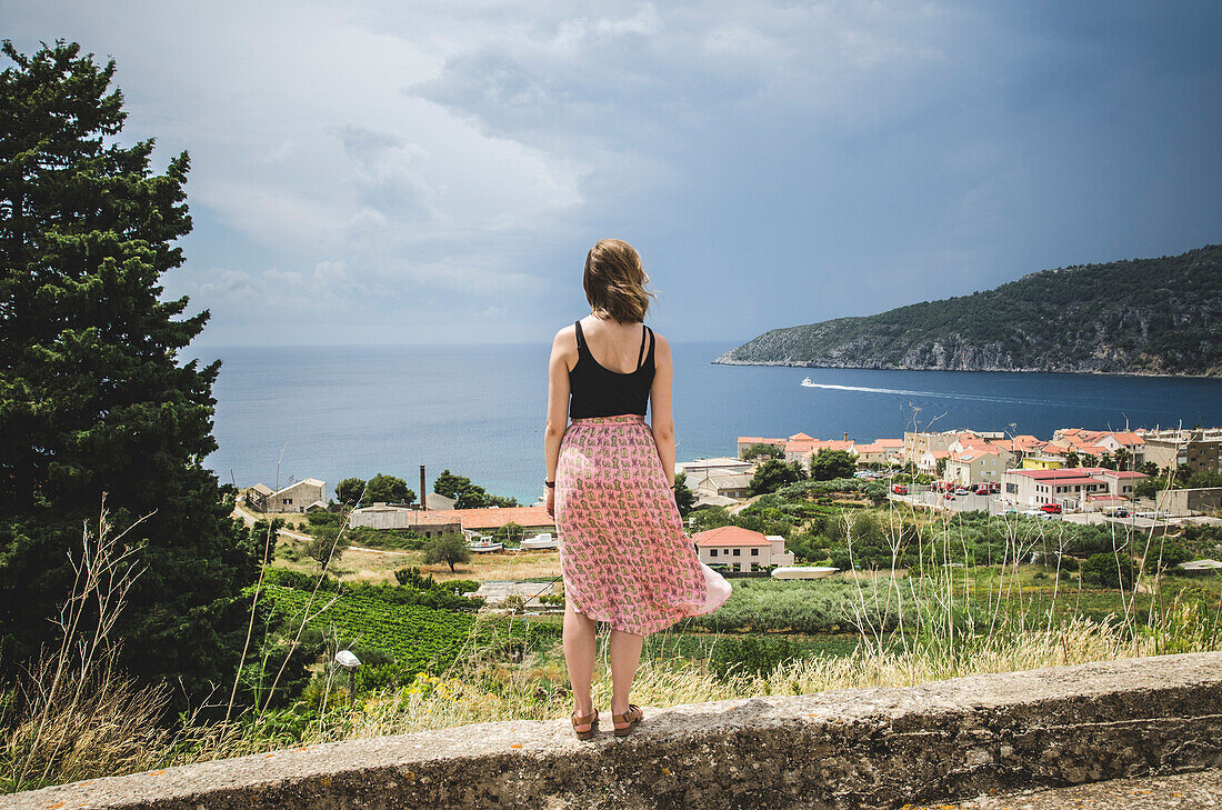Junge Frau Blick über die Stadt Komiza, Insel Vis, Kroatien
