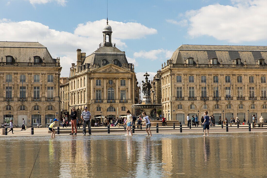 Der Wasserspiegel (Miroir d'eau) vor dem Place de la Bourse mit Menschen, Place de la Bourse, Bordeaux, Gironde, Nouvelle-Aquitaine, Frankreich, Europa