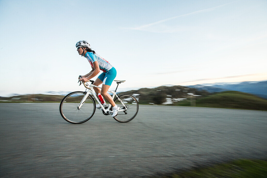 Junge Frau auf ihrem Rennrad in den Kitzbühler Alpen, Kitzbühlerhorn, Tirol, Österreich