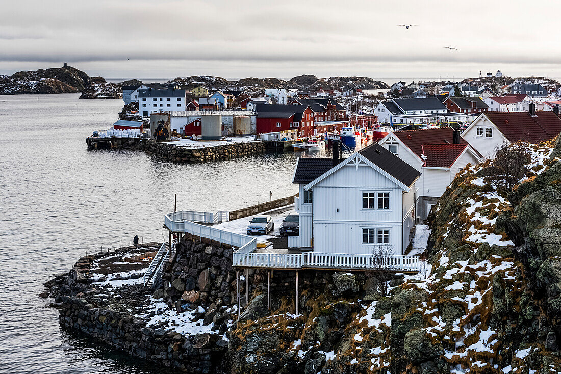 'Häuser entlang der Küste mit Wolken über dem Ozean und Horizont in der Ferne; Lofoten, Nordland, Norwegen'