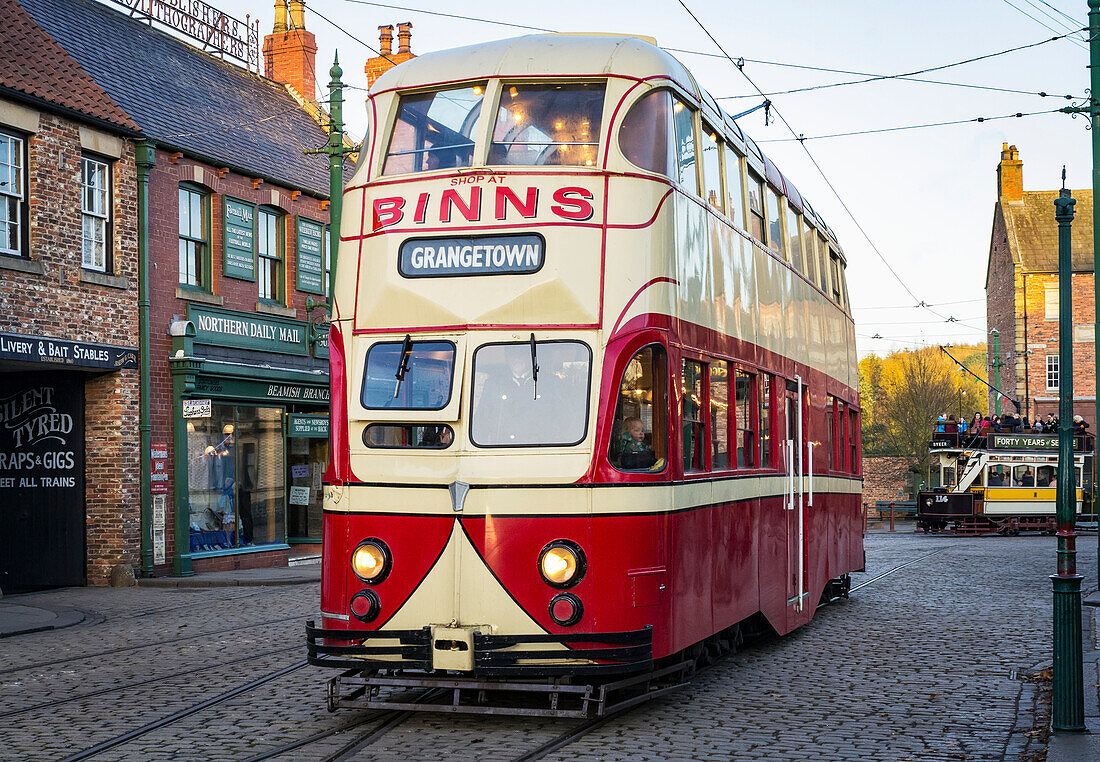 'Tram traveling along High Street in Beamish, the Living Museum of the North. These trams became fondly known as ‘Balloons’ because of their streamlined bloated appearance; Beamish, County Durham, England'