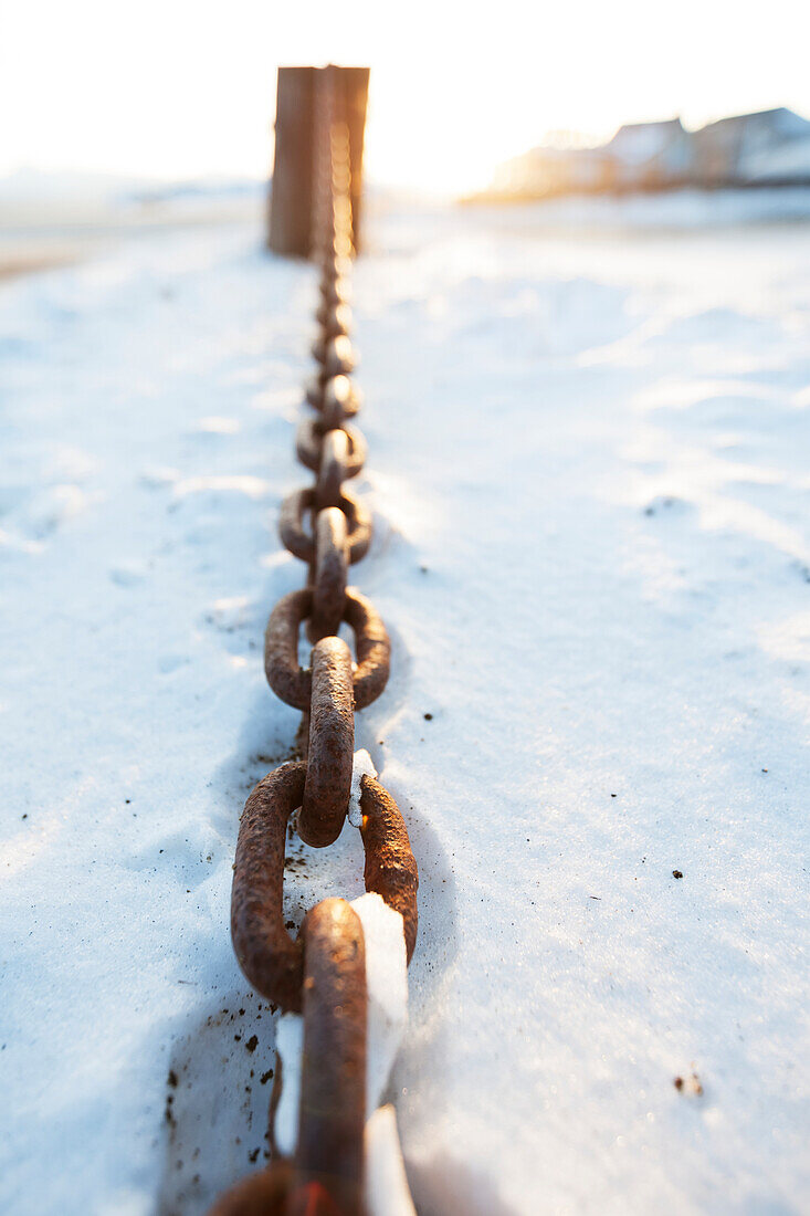 Eine rostige Metallkette, die in den Schnee legt, Alaska, Vereinigte Staaten von Amerika