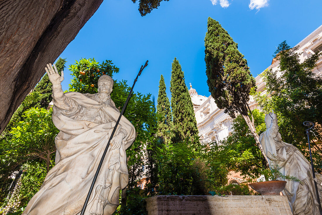 Statuen auf dem Friedhof Campo Santo Teutonico mit der Kuppel des Petersdom Basilica di San Pietro im Hintergrund, Rom, Latium, Italien