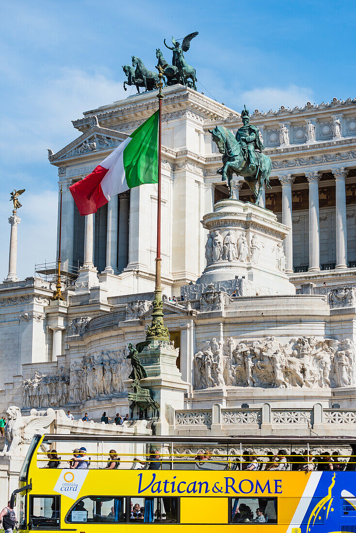 Das Monument Monumento a Vittorio Emanuele II mit Nationalflagge und Touristenbus, Rom, Latium, Italien