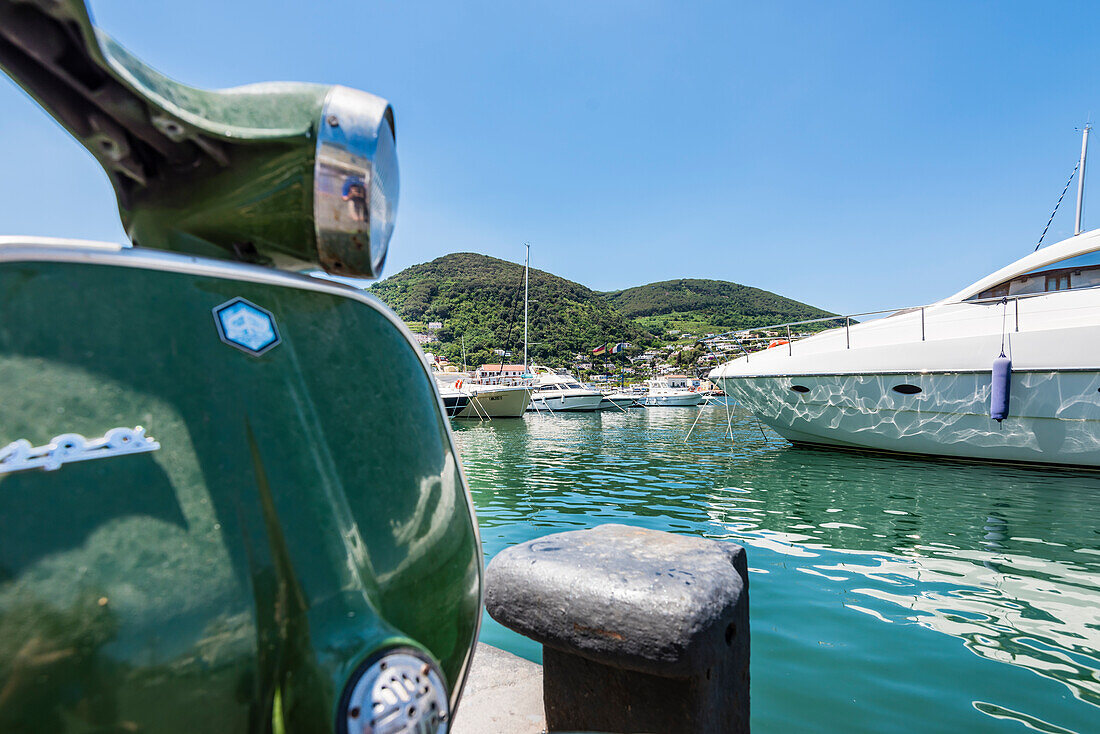 A Vespa and yachts in the harbour of Ischia Porto, Ischia, the Gulf of Naples, Campania, Italy