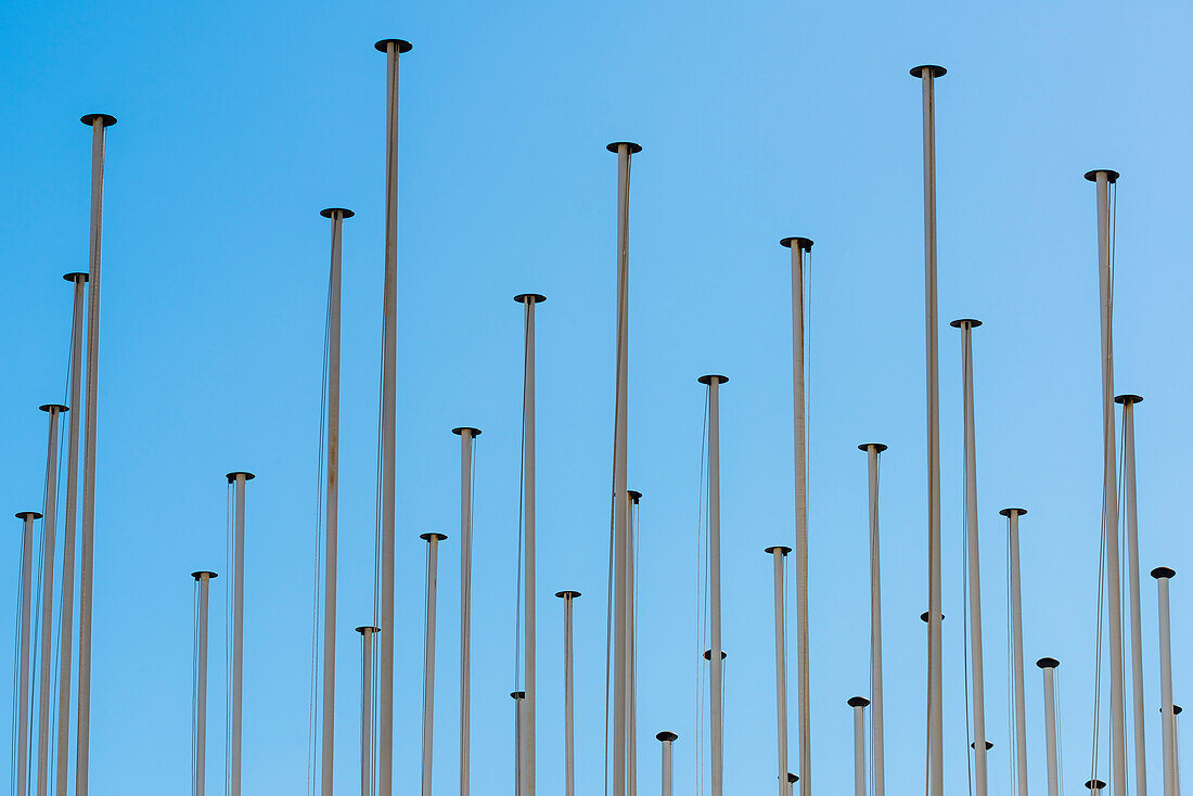 A accumulation of flagpoles in front of blue sky, Lisbon, Portugal