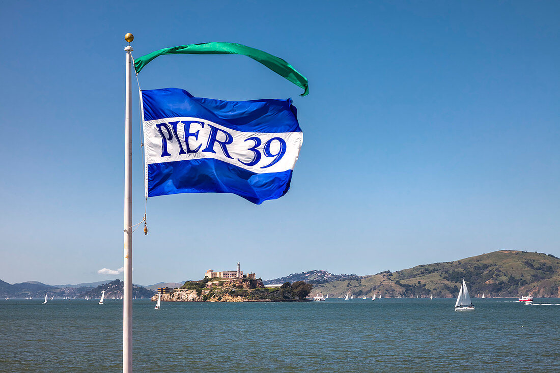 Pier 39 flag in front of Alcatraz, San Francisco, California, USA