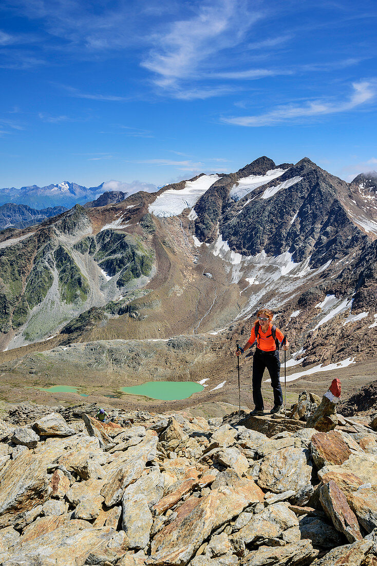 Frau beim Wandern steigt zum Wilden Freiger auf, Bergseen und Feuersteine im Hintergrund, Wilder Freiger, Stubaier Alpen, Tirol, Österreich