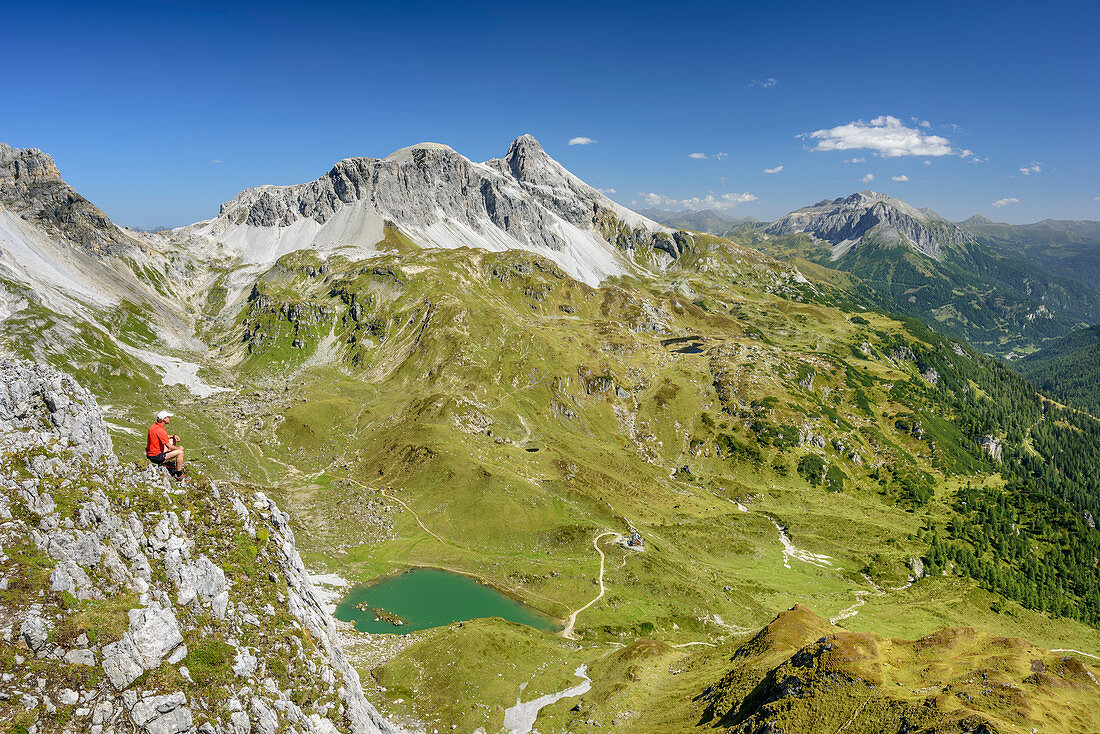 Man hiking looking towards cirque Zaunerkar with lake Zaunersee and Grosses Mosermandl, Stierkarkopf, valley Riedingtal, Radstadt Tauern, Lower Tauern, Carinthia, Austria