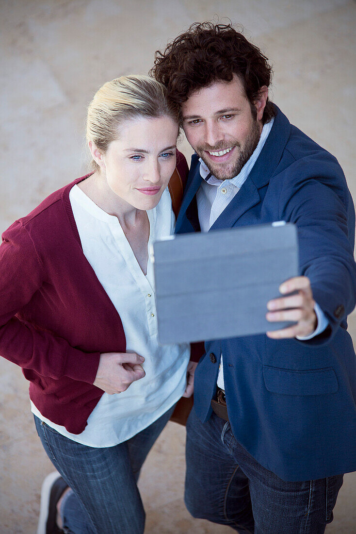 Couple using digital tablet to take a selfie