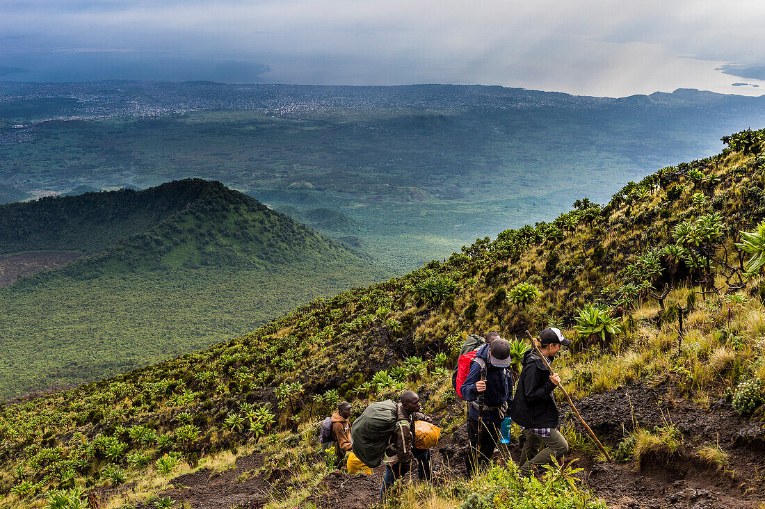 Trekkers on the steep slopes of Mount Nyiragongo, Virunga National Park, Democratic Republic of the Congo, Africa