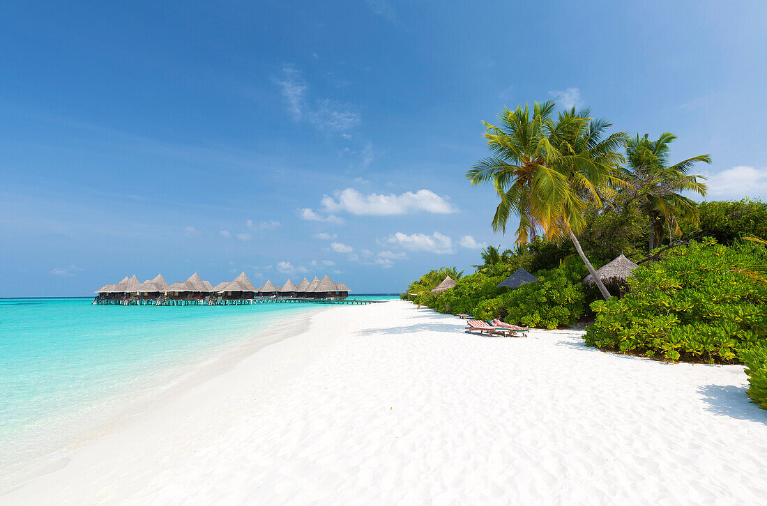 Blick entlang des tropischen Strandes zu den Überwasser-Villen, Coco Palm Resort, Dhuni Kolhu, Baa-Atoll, Malediven, Indischer Ozean, Asien