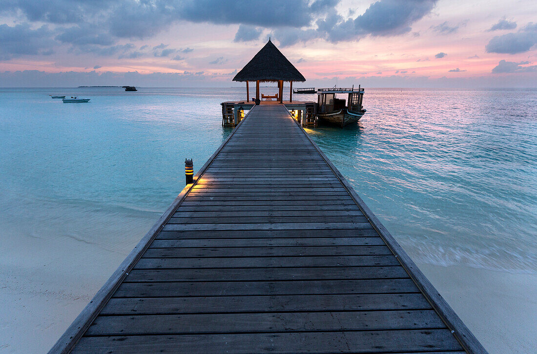Holzsteg und Boot bei Sonnenuntergang, Coco Palm Resort, Dhuni Kolhu, Baa-Atoll, Malediven, Indischer Ozean, Asien