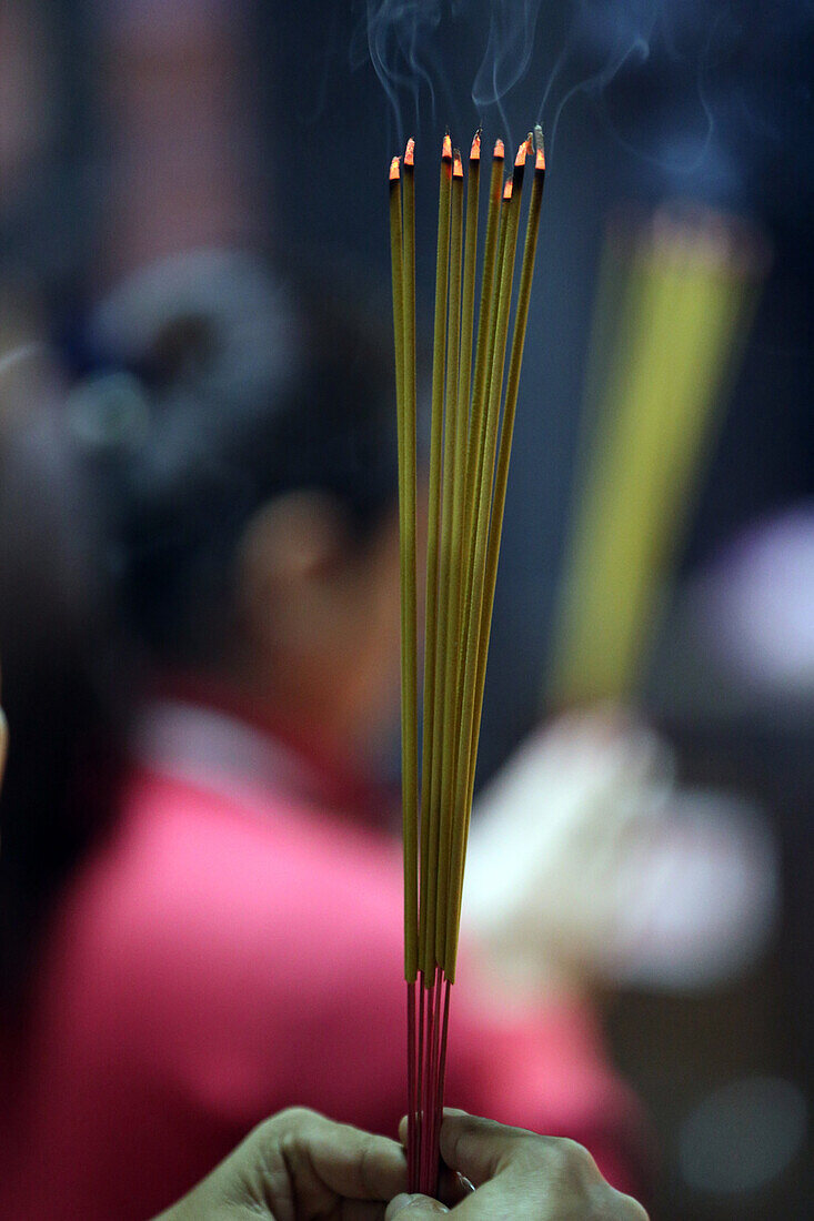 Worshipper burning incense sticks, Taoist temple. Jade Emperore pagoda (Chua Phuoc Hai), Ho Chi Minh City, Vietnam, Indochina, Southeast Asia, Asia