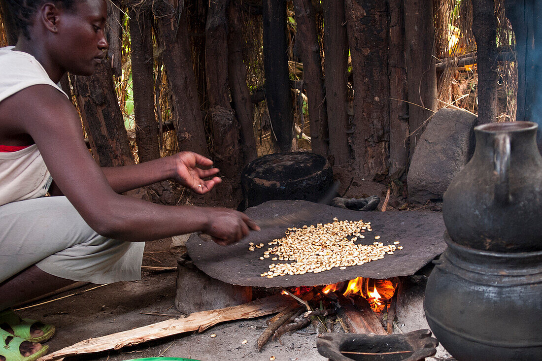 Eine Frau brät Kaffeebohnen auf einem offenen Feuer, Äthiopien, Afrika