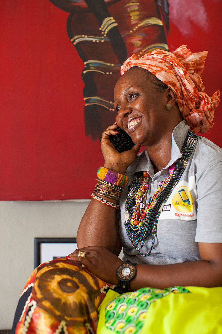 A woman smiling whilst talking on her mobile phone, Nigeria, West Africa, Africa