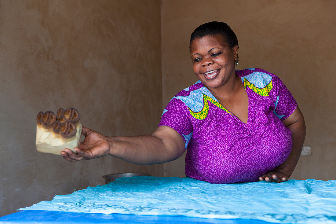 Eine Frau, die einen neuen Batikabdruck, Tansania, Ostafrika, Afrika