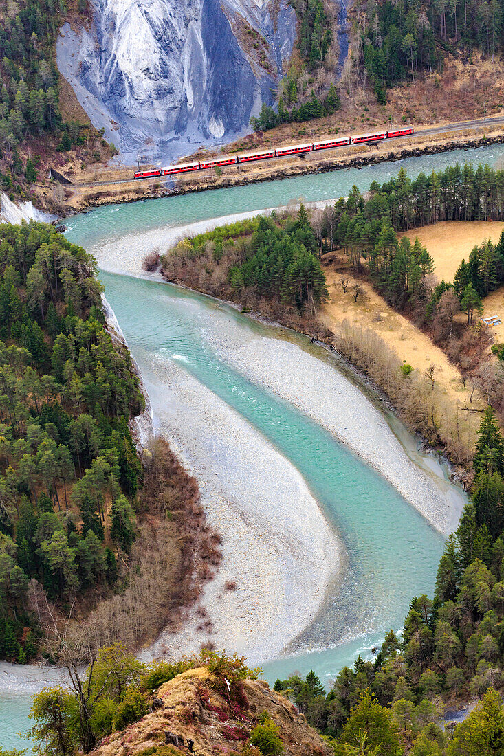 The Red Train travels along the Rhine River, Rhein Gorge (Ruinaulta), Flims, Imboden, Graubunden, Switzerland, Europe