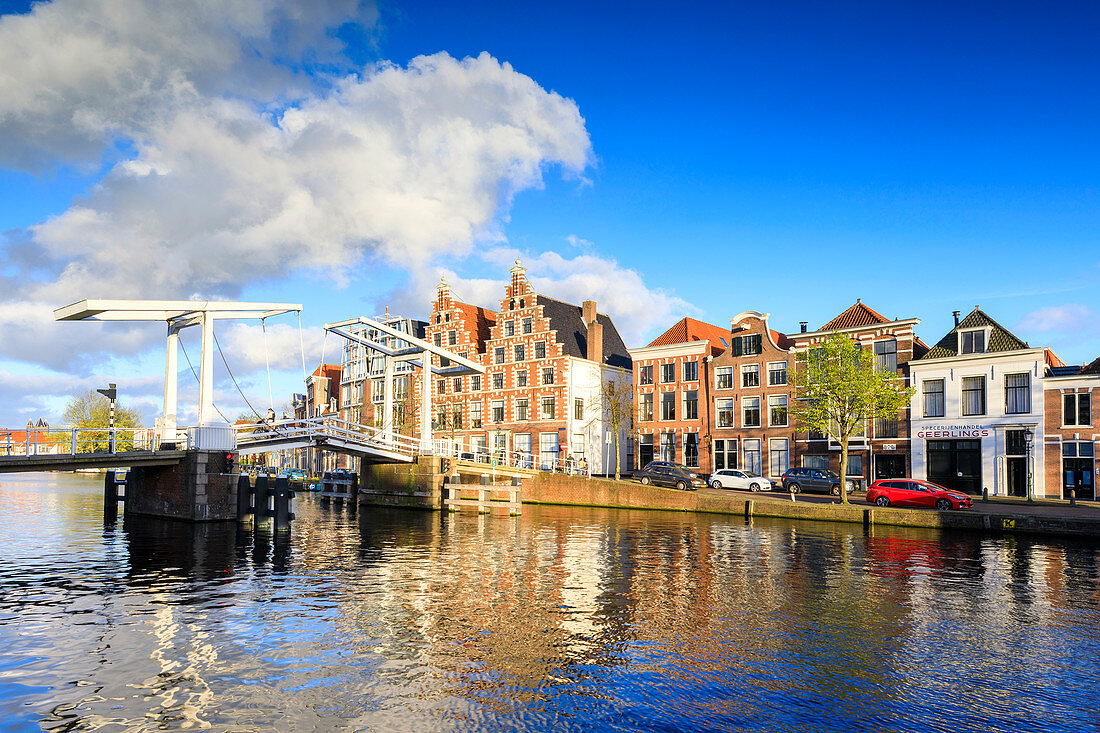 Blauer Himmel und Wolken an typischen Häusern spiegelt sich im Kanal des Flusses Spaarne, Haarlem, Nordholland, Niederlande, Europa